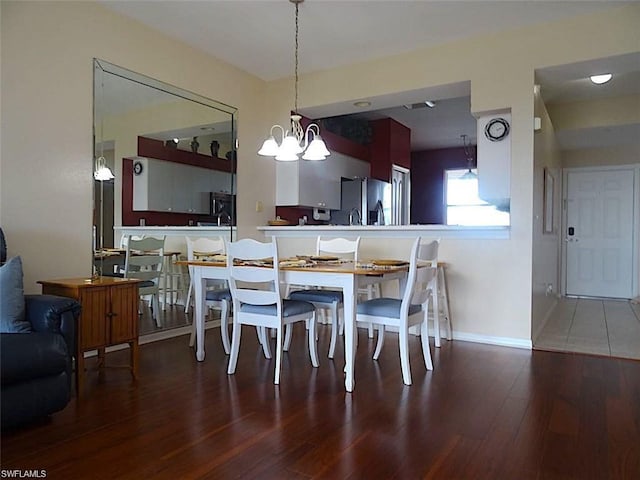 tiled dining room with a chandelier