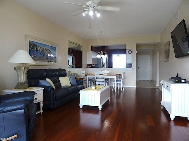 living room with dark hardwood / wood-style floors and ceiling fan with notable chandelier