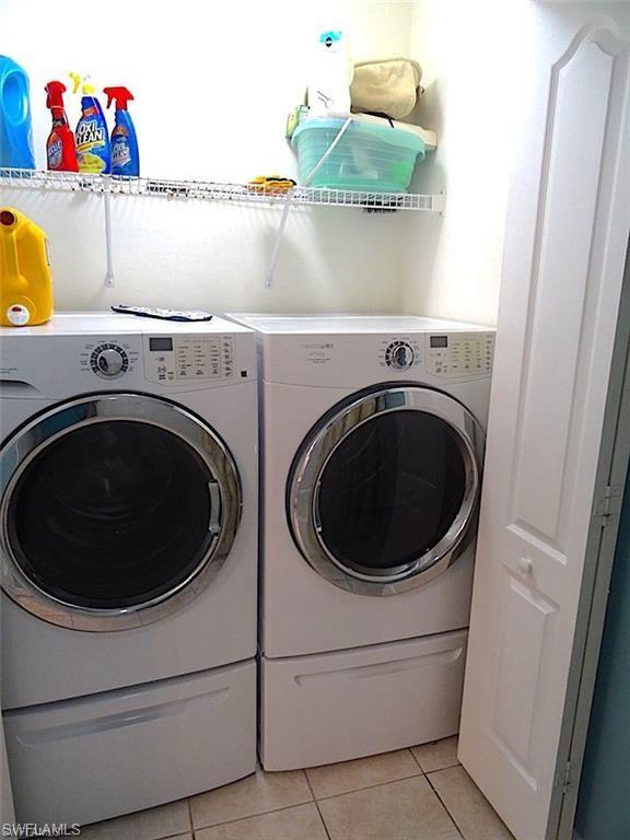 washroom featuring light tile floors and separate washer and dryer