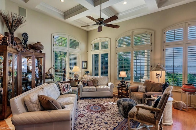 living room featuring light hardwood / wood-style floors, coffered ceiling, ceiling fan, and beamed ceiling