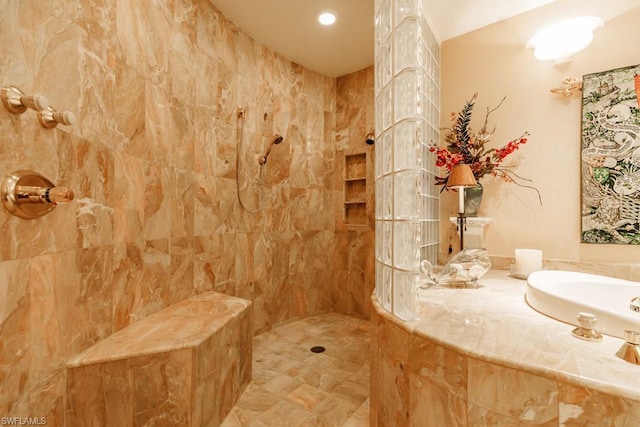 bathroom featuring tile walls, a tile shower, and tile floors