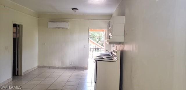 kitchen featuring white cabinetry, electric stove, a wall mounted AC, and light tile flooring