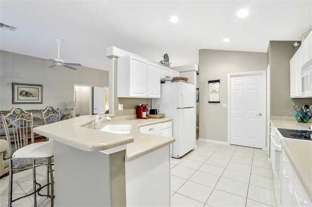 kitchen featuring white appliances, ceiling fan, sink, a kitchen breakfast bar, and white cabinetry