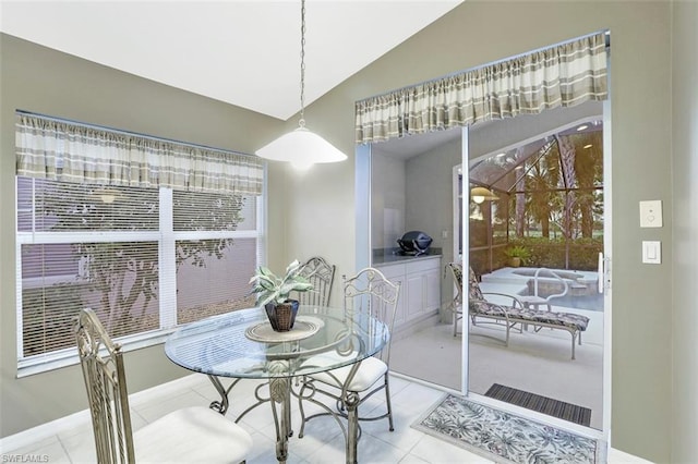 dining area featuring lofted ceiling and light tile floors