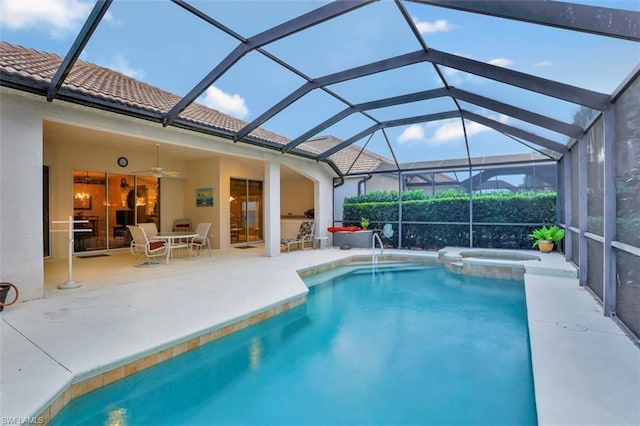 view of pool with an in ground hot tub, glass enclosure, ceiling fan, and a patio area