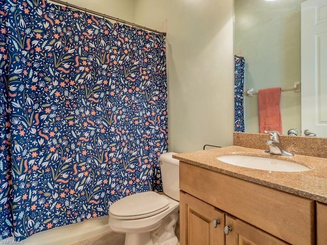 bathroom with toilet, tile floors, and vanity with extensive cabinet space