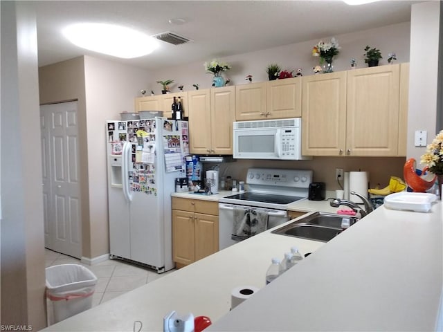 kitchen with light brown cabinets, white appliances, sink, and light tile floors