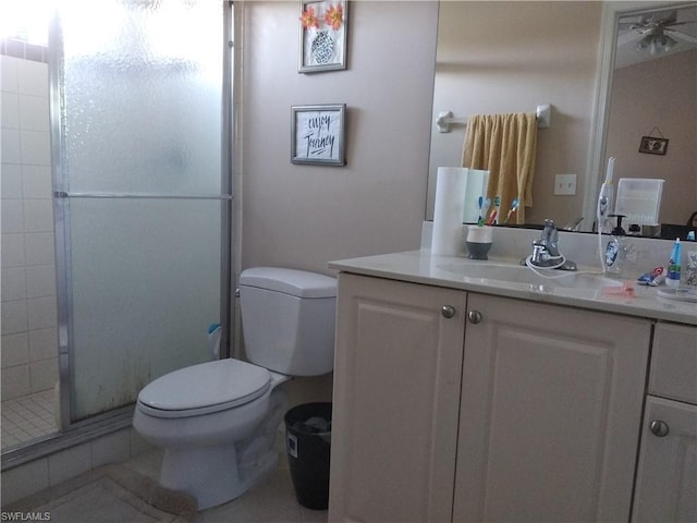 bathroom featuring toilet, ceiling fan, vanity with extensive cabinet space, tile flooring, and an enclosed shower