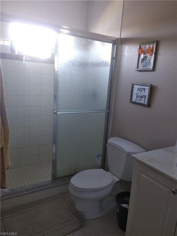 bathroom with vanity, tile flooring, a shower with shower door, and toilet