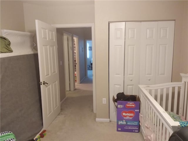 carpeted bedroom featuring a closet and a nursery area