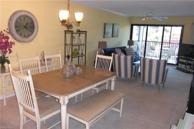 carpeted dining space with ceiling fan with notable chandelier