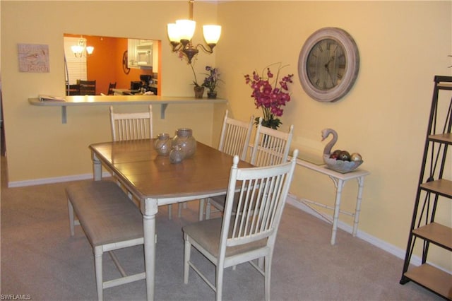 carpeted dining space featuring a chandelier