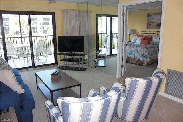 living room with ceiling fan, a wealth of natural light, and light colored carpet