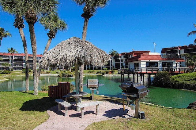 view of property's community with a lawn and a water view