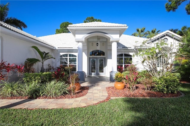 view of front of house with a front yard and french doors