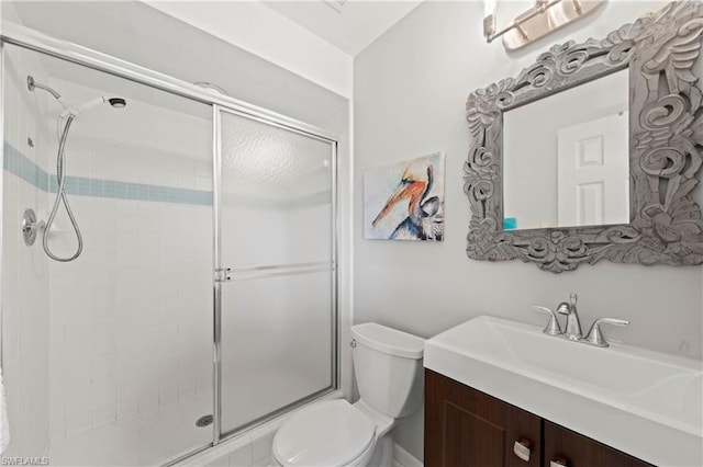 bathroom with vanity, a shower with door, and toilet