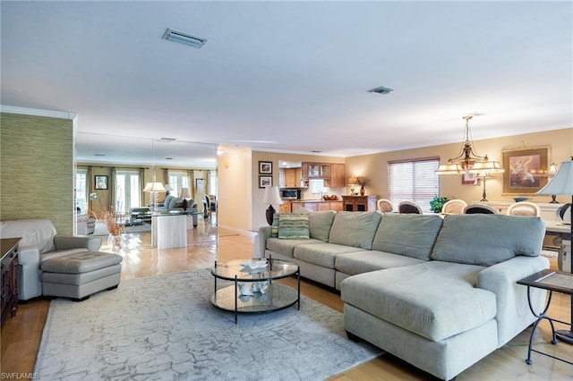 living room with light hardwood / wood-style floors and a notable chandelier