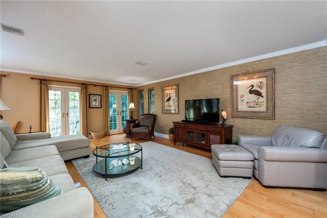 living room featuring crown molding, french doors, and light hardwood / wood-style flooring