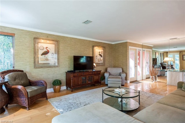 living room featuring plenty of natural light, wood-type flooring, and crown molding