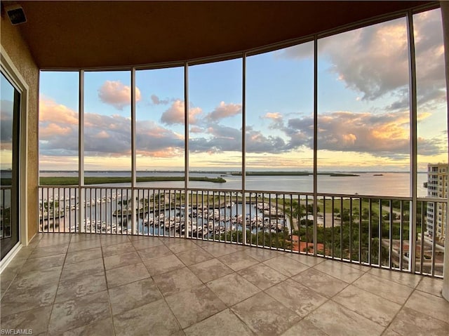 unfurnished sunroom featuring a water view