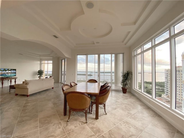 sunroom / solarium with a raised ceiling and a healthy amount of sunlight