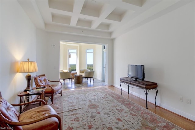 sitting room with coffered ceiling, beamed ceiling, and light hardwood / wood-style flooring