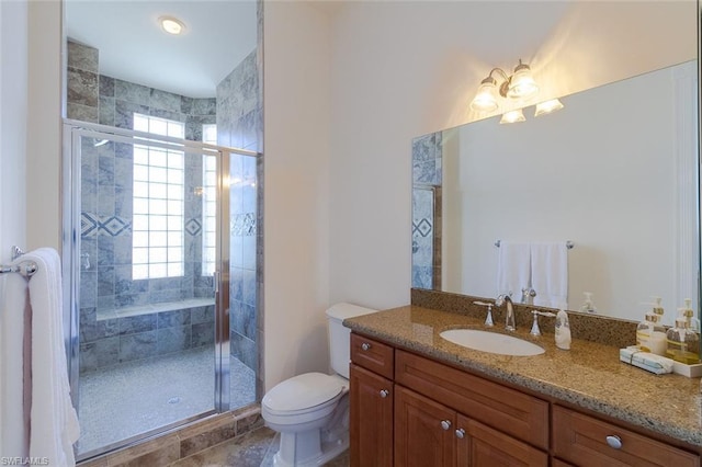 bathroom featuring walk in shower, toilet, vanity, and a healthy amount of sunlight