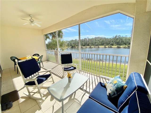 sunroom / solarium with ceiling fan and a water view