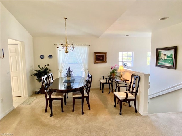 dining space featuring a notable chandelier, lofted ceiling, and light colored carpet