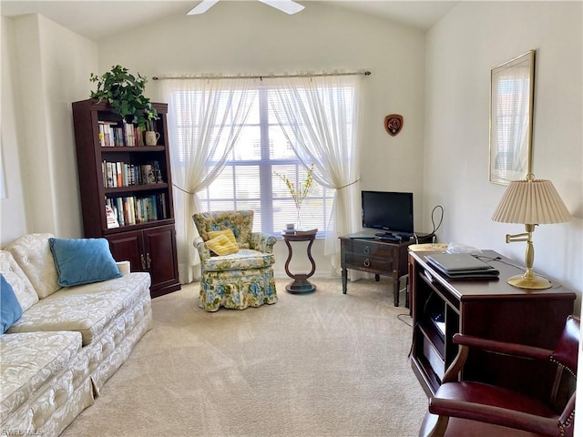 living area featuring ceiling fan, vaulted ceiling, and light colored carpet