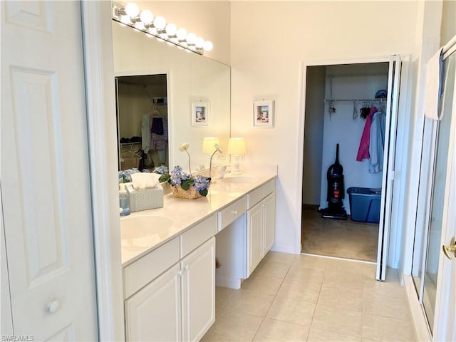 bathroom featuring tile flooring, dual vanity, and walk in shower