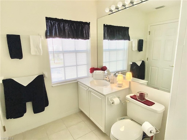 bathroom with toilet, vanity with extensive cabinet space, and tile floors