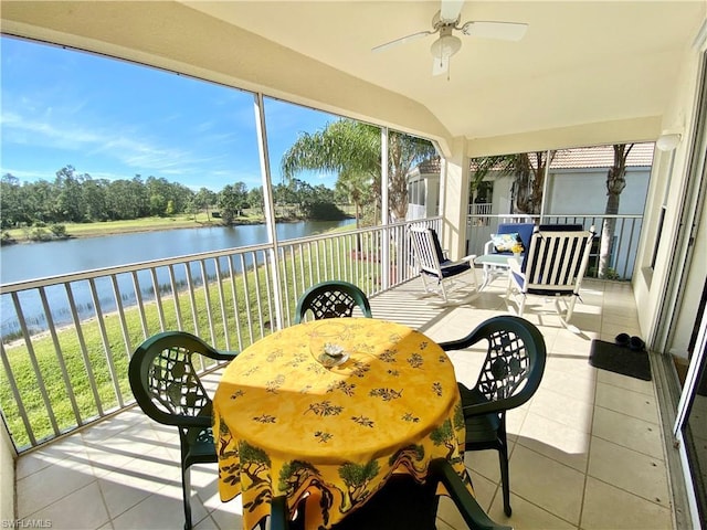 sunroom featuring ceiling fan, vaulted ceiling, and a water view