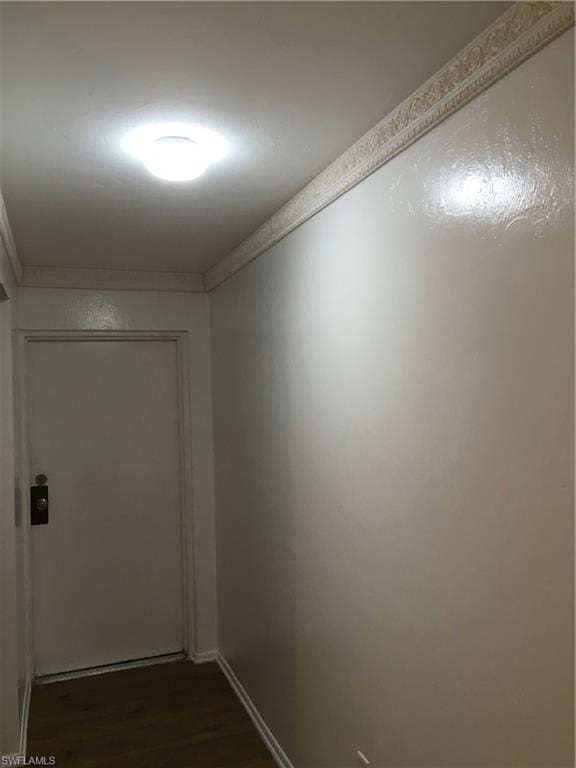 hallway featuring dark hardwood / wood-style floors and ornamental molding