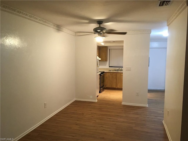 empty room featuring ceiling fan, dark hardwood / wood-style floors, and sink