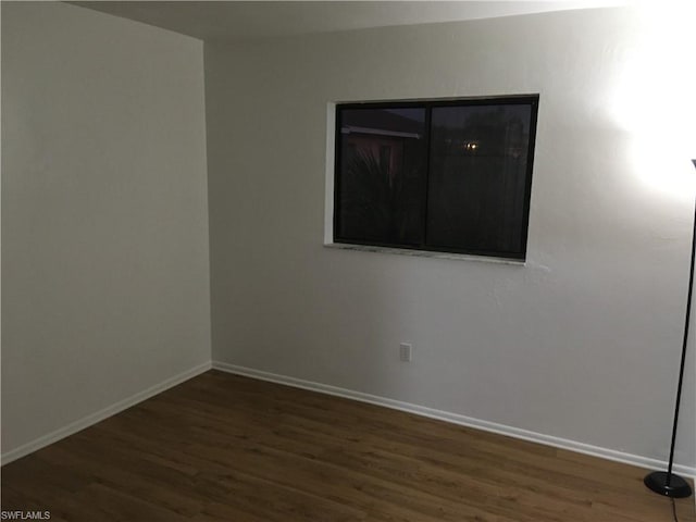 unfurnished room with dark hardwood / wood-style floors