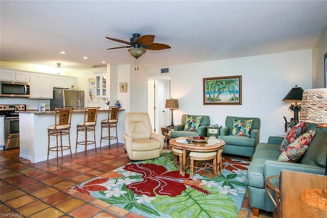 living room with dark tile flooring and ceiling fan