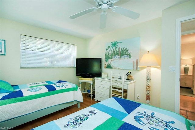 bedroom with dark hardwood / wood-style flooring and ceiling fan