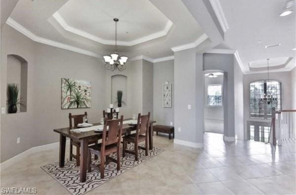 dining area with a tray ceiling, light tile floors, and a notable chandelier