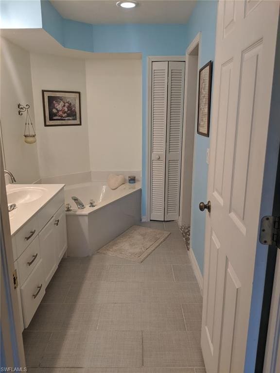 bathroom featuring vanity, tile flooring, and a bathtub