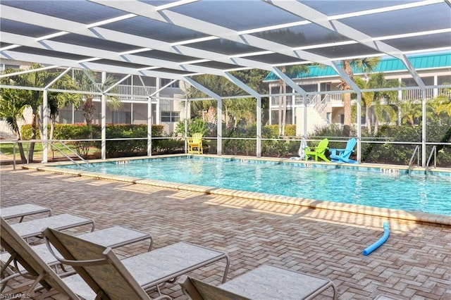 view of swimming pool featuring a patio and a lanai