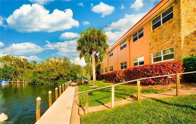 view of home's community with a lawn and a water view