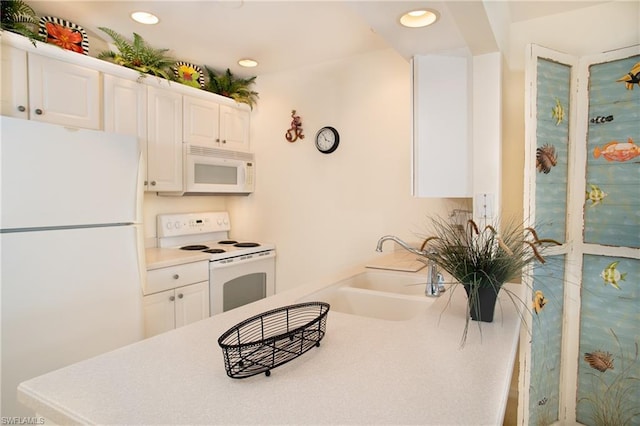 kitchen with white cabinets, white appliances, kitchen peninsula, and sink