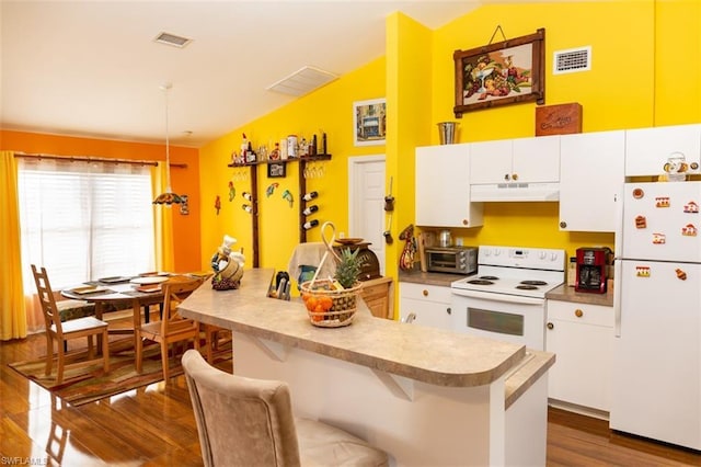 kitchen featuring white cabinets, hardwood / wood-style floors, white appliances, a breakfast bar area, and lofted ceiling