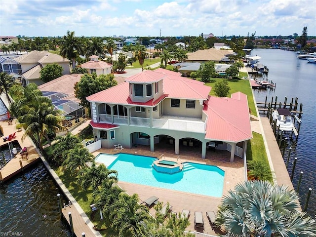 view of swimming pool featuring a boat dock, a patio, and a water view