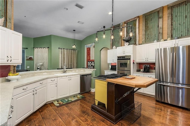 kitchen featuring white cabinets, appliances with stainless steel finishes, dark wood-type flooring, and sink