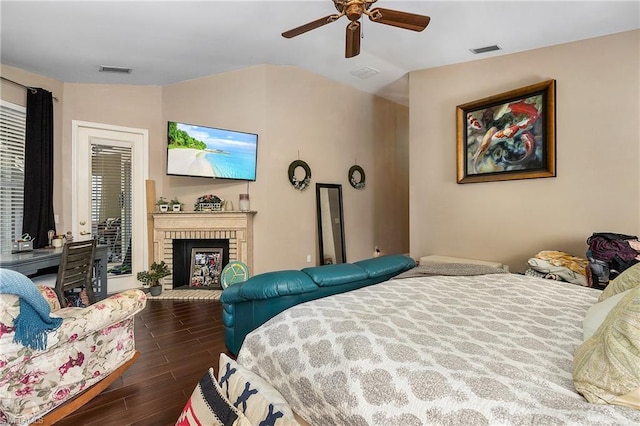 bedroom with lofted ceiling, a brick fireplace, ceiling fan, and dark hardwood / wood-style floors