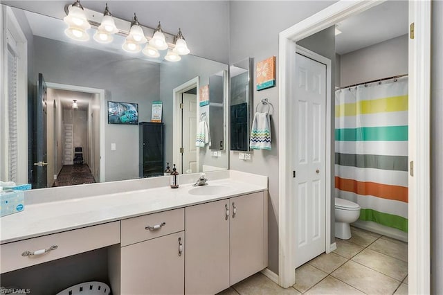 bathroom featuring toilet, tile floors, and vanity