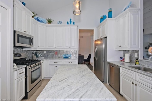 kitchen with white cabinetry, backsplash, and stainless steel appliances