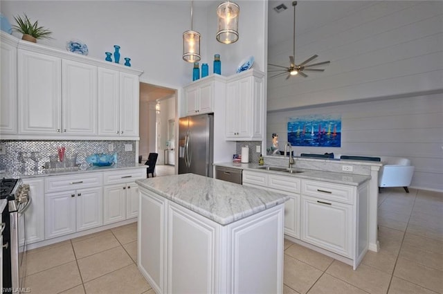 kitchen with ceiling fan, a kitchen island, appliances with stainless steel finishes, and sink